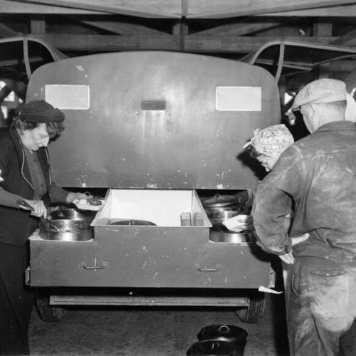 [Workers at Hunters Point Drydock getting food from the back of a mobile lunchroom]