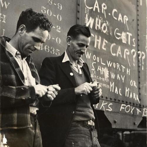 [John McAndrews and Charles Knauff standing next to a "hot" railroad car during warehousemen's strike]