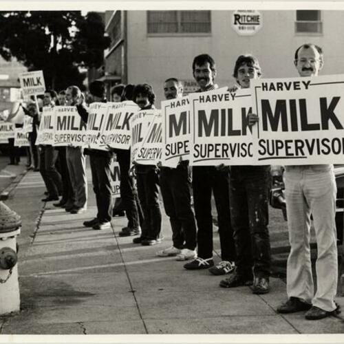["Harvey's Human Billboard" - Group of people holding "Harvey Milk Supervisor" signs on Market Street at Duboce]