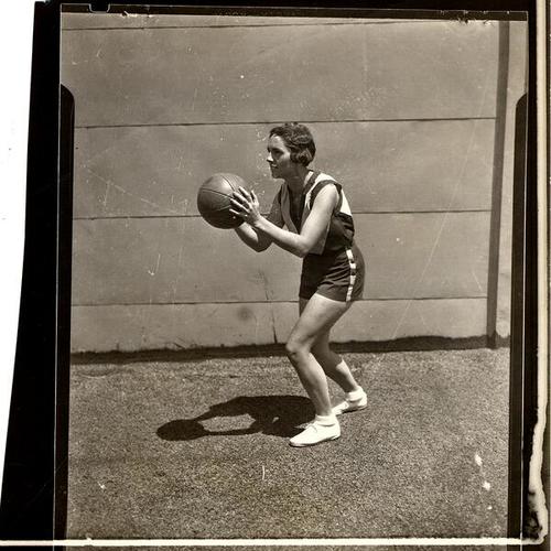 [Young woman practicing basketball]