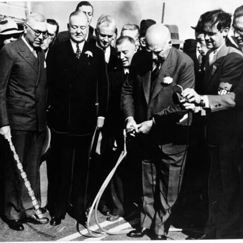 [Former California Governor Frank Merriam opens the San Francisco-Oakland Bay Bridge while former Mayor Angelo Rossi, former President Herbert Hoover and chief engineer C. H. Purcell look-on]