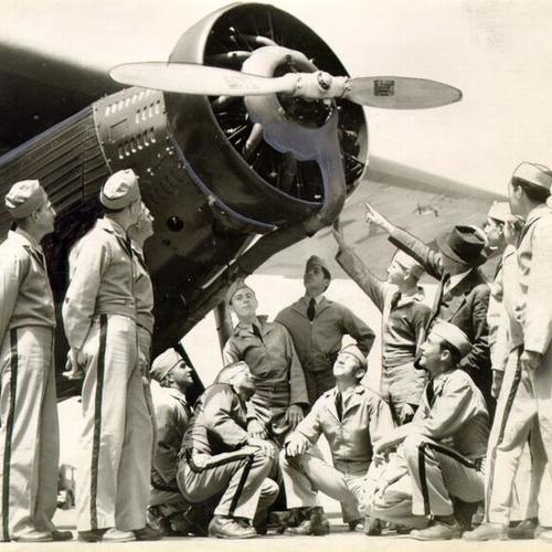 [Group of men posing with an airplane at Crissy Field]