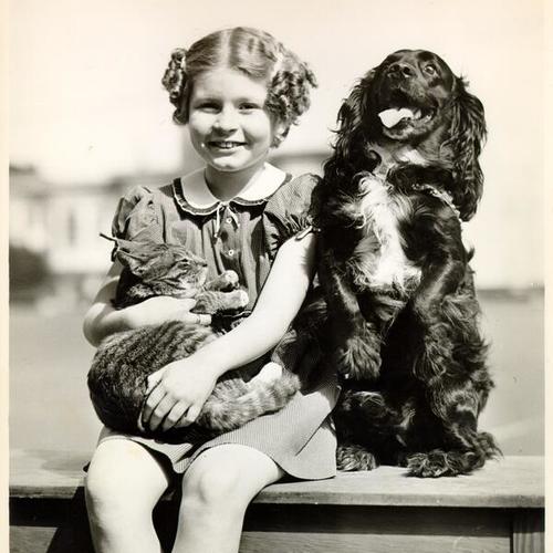 [McCoppin School student Jacqueline Darling posing with her pet cat, "Tige", and dog, "Bing"]