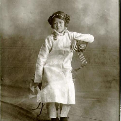 [Young girl sitting in a chair posing for a photograph]