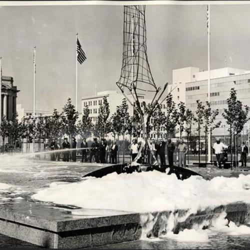 [Firemen using hoses to sluice foam from the fountain at Civic Center Plaza]