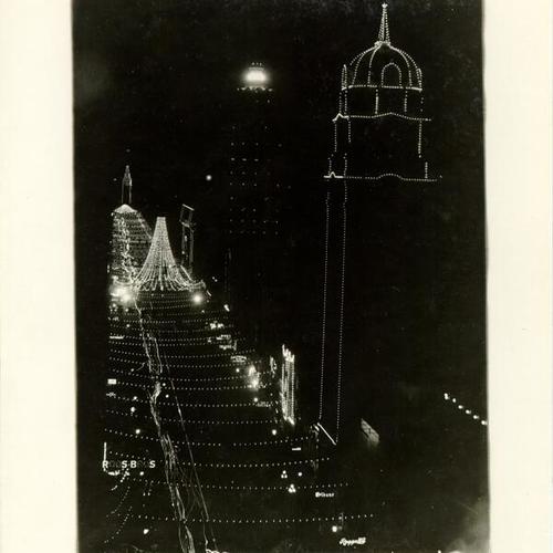 [Nighttime view of illuminated decorations on Market Street, looking east from the Phelan Building to the Ferry Building]