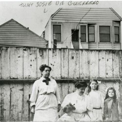 [Portrait of two women and three children in backyard on Valley Street]