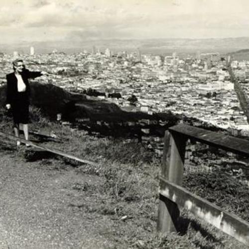 [Joan Magnusson standing near a broken railing along Twin Peaks Boulevard]