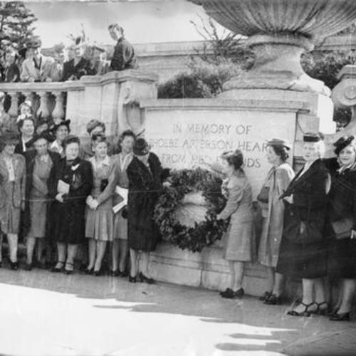 [Unidentified women placing a wreath on the monument to Phoebe Apperson Hearst in Golden Gate Park]