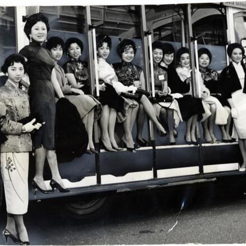 [Participants in the 1961 "Miss Chinatown U. S. A" contest riding a cable car]