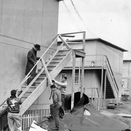 [Superintendent of Schools Herbert C. Clish inspecting damage done by part of the roof of Lake Merced School after it was blown into a nearby housing project by high winds]