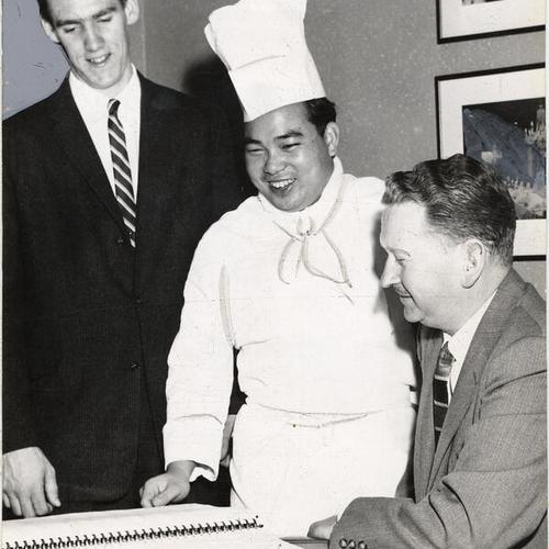 [City College of San Francisco students Larry Dillon and Sammy Louis posing with St. Francis Hotel employee Louis Chavey]