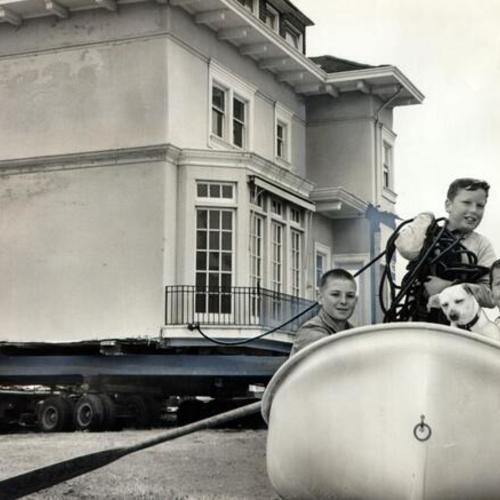 [Youngsters James and John Garibaldi and John Gallagher attempt to pull the Moffitt mansion on their boat]