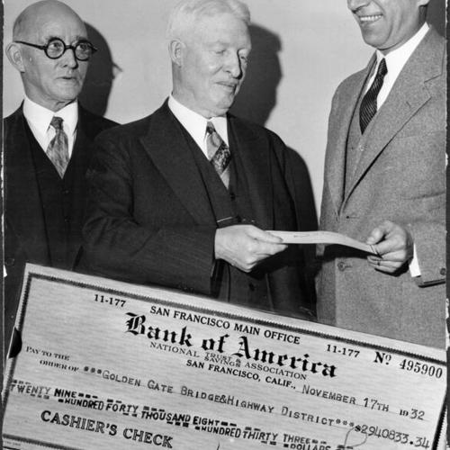 [John R. Ruckstell and William P. Filmer accepting a  check from A. J. Gock for the span construction of Golden Gate Bridge]
