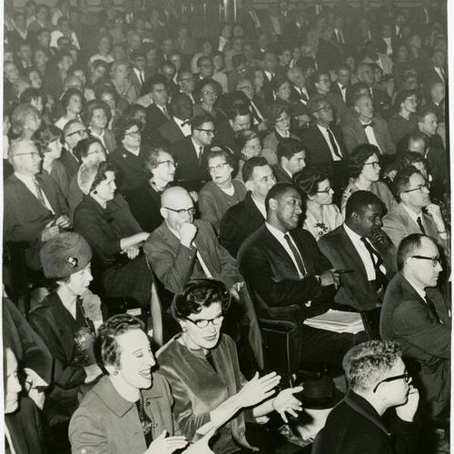 [Audience attending a meeting at Lowell High School to decide the fate of the school's academic future]
