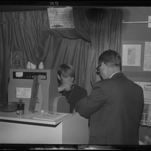 Interior view of person behind cash register with customer
