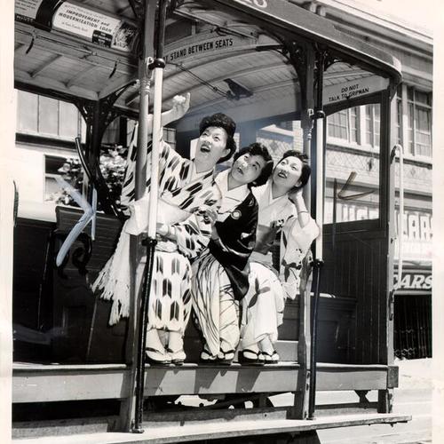 [Three women riding a cable car]