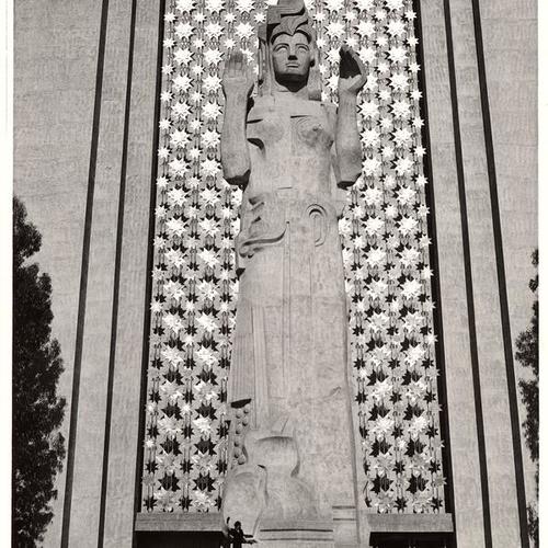 ['Pacifica', Ralph Stackpole's 80-foot theme figure of the Exposition, standing before a prayer curtain of metal bangles, Golden Gate International Exposition on Treasure Island]
