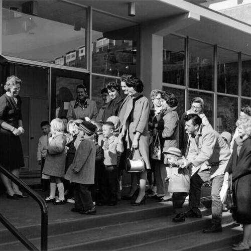 [Group of children and adults gathered at the entrance to Clarendon Elementary School]