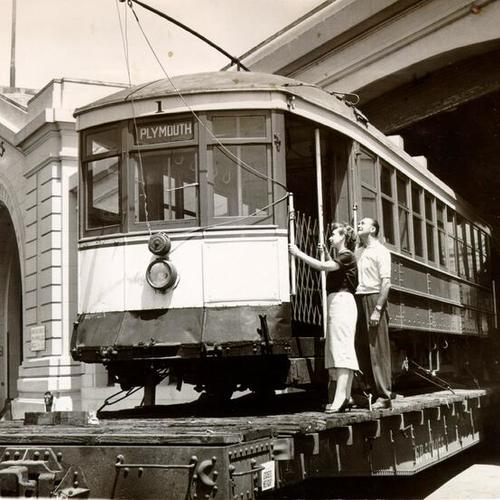 [Ova Belle Royce and Herb Van Zante looking at an old streetcar being stored at the Port Authority warehouse at Pier 25]