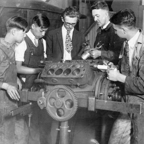[Students being instructed on the mechanics of an engine at Mission High School]