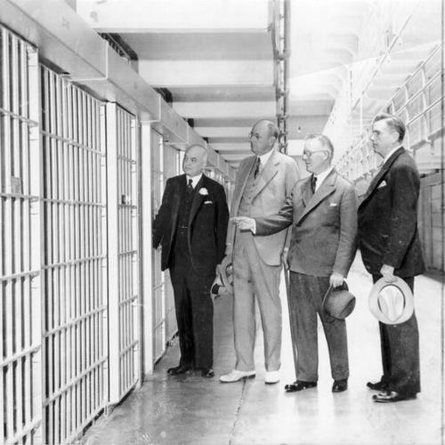 [San Francisco Mayor Angelo Rossi, United States Attorney General Homer S. Cummings, Warden James A. Johnston and San Francisco Chief of Police Quinn inspect cells at Alcatraz Island prison]