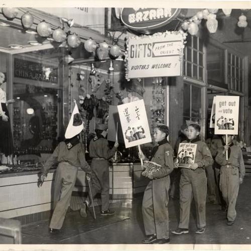 [Boy Scouts in Chinatown with signs urging people to vote]