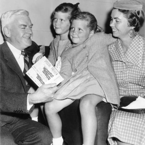 [Thomas J. Mellon presenting Mrs. Dan Williams, accompanied by her daughters Sandra and Nini, with a prize for being the millionth moviegoer to see "This Is Cinerama"]