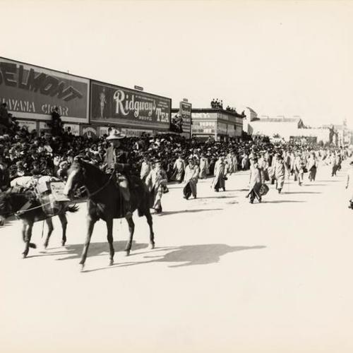 [Man on horseback preceding a group of costumed men on foot, Parade from Portola Festival, October 19-23, 1909]