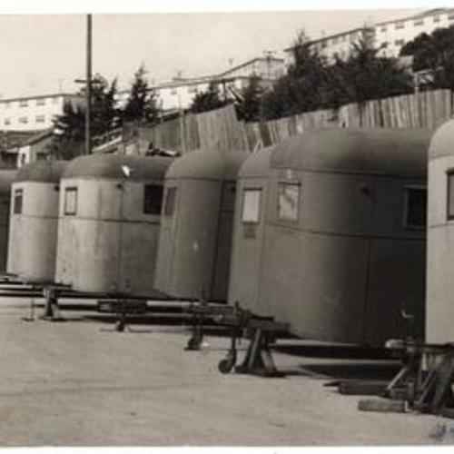 [Trailers to be used as housing for small families lined up in a parking lot at Hunters Point]
