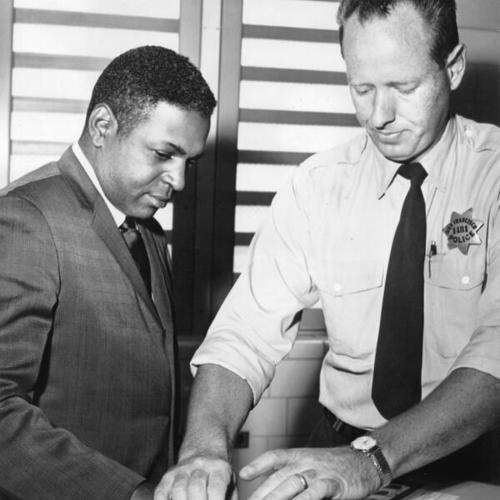 [Terry Francois being fingerprinted by Police Officer Donald Ostrem at Hall of Justice for picketing]