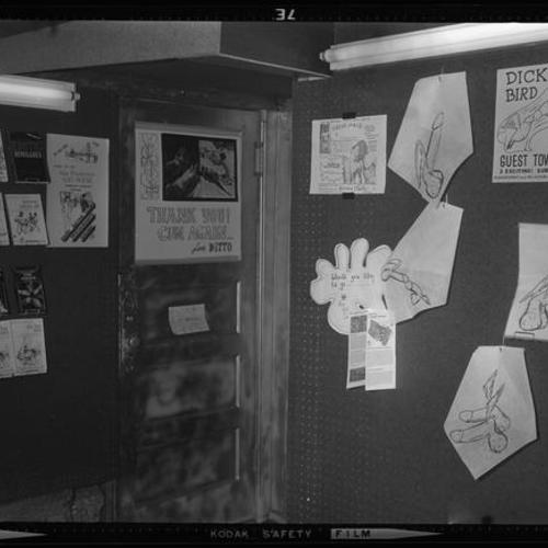 Interior view of door and walls with publications, drawings, and signs