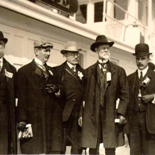 [James Rolph flanked by several unidentified men]