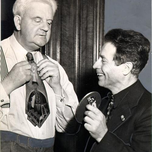 [Artist Beniamino Bufano watching Mayor Roger Lapham try on a tie of his design]