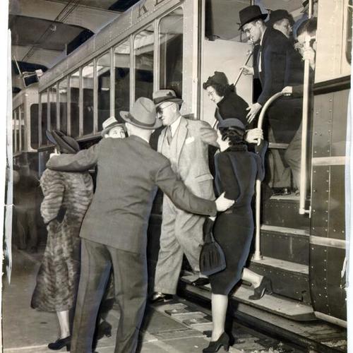 [Group of people exiting the first electric train to carry passengers across the San Francisco-Oakland Bay Bridge]