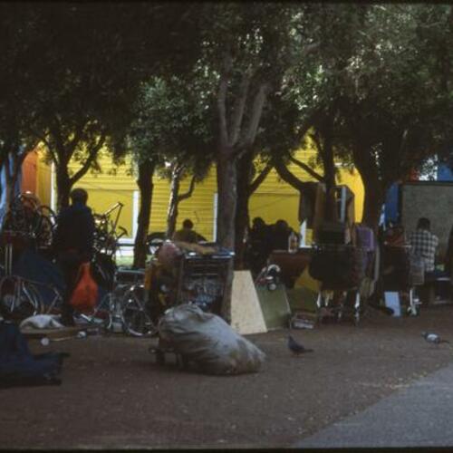 [People with bicycle parts and other personal belongings at Civic Center]