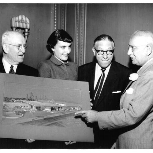 [Four people looking at an artist's rendering of proposed Marina Branch Library]