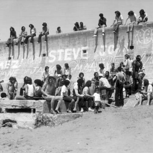 [Group of people hanging out by the wall at Ocean Beach]