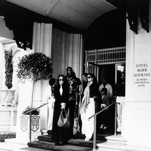 [Bianca Jagger, Ollie Brown and others standing at the entrance to the Mark Hopkins Hotel]