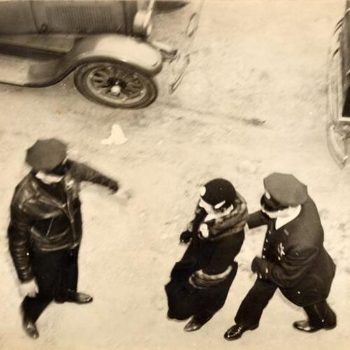 [Two police officers escorting a woman during the 1937 WPA strike]