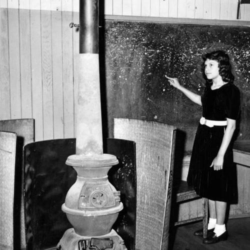 [Unidentified girl standing in a classroom at Horace Mann Junior High School]