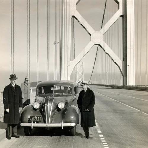 [Group of people standing next to a car on the San Francisco-Oakland Bay Bridge]