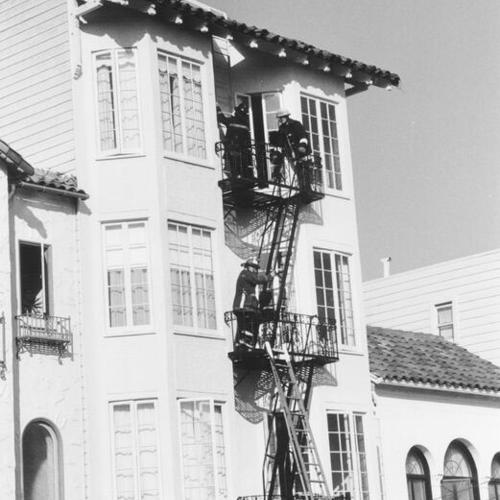 [Fire fighters climbing building through fire escape during aftermath of Loma Prieta earthquake]