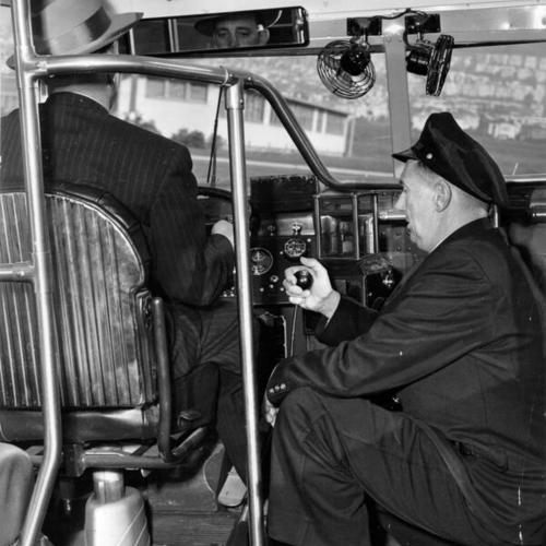 [Municipal Railway instructors William D. Ratto and William McRobbie demonstrating a device designed to prevent accidents by student bus drivers]