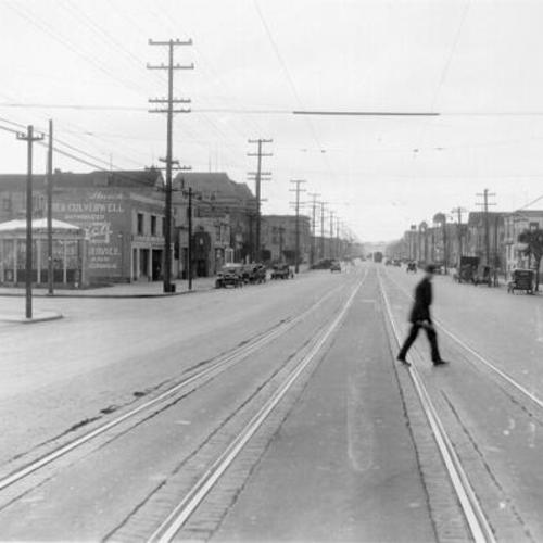 [Man walking across train tracks on Geary street at 4th avenue]