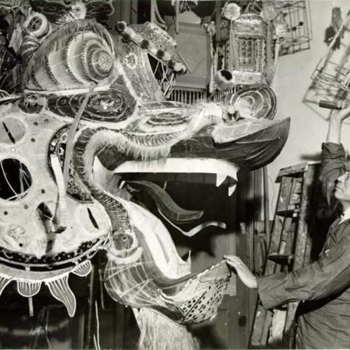 [Yip Loy, a Chinatown lantern and dragon craftsmen, working on a dragon for the upcoming Rice Bowl celebration]