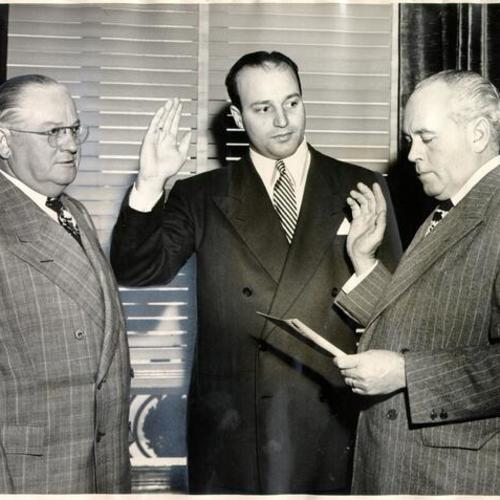 [Mayor Elmer E. Robinson watching Judge Edward Murphy swear in Joseph Alioto as a new member of the Board of Education]