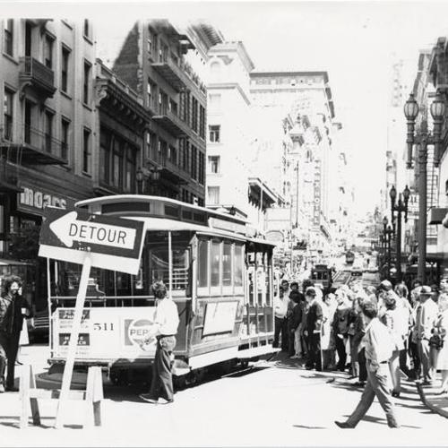[Crowd of people waiting to ride a cable car on Powell Street]