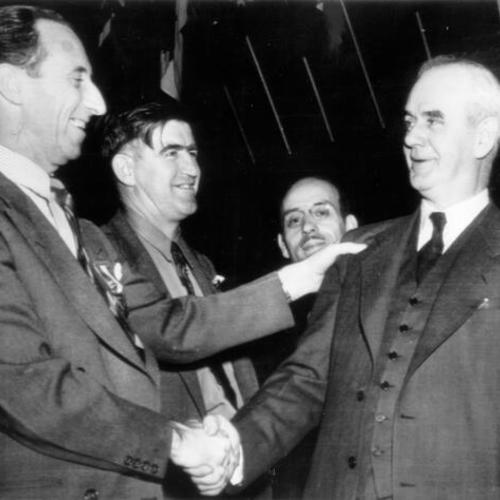 [Harry Bridges (left) shakes hands with Phillip Murray, re-elected CIO president]