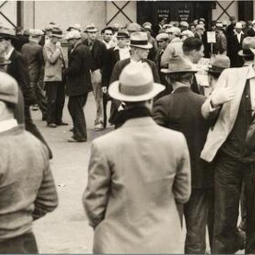 [Crowd of longshoremen assembled at waterfront at end of 1934 strike]